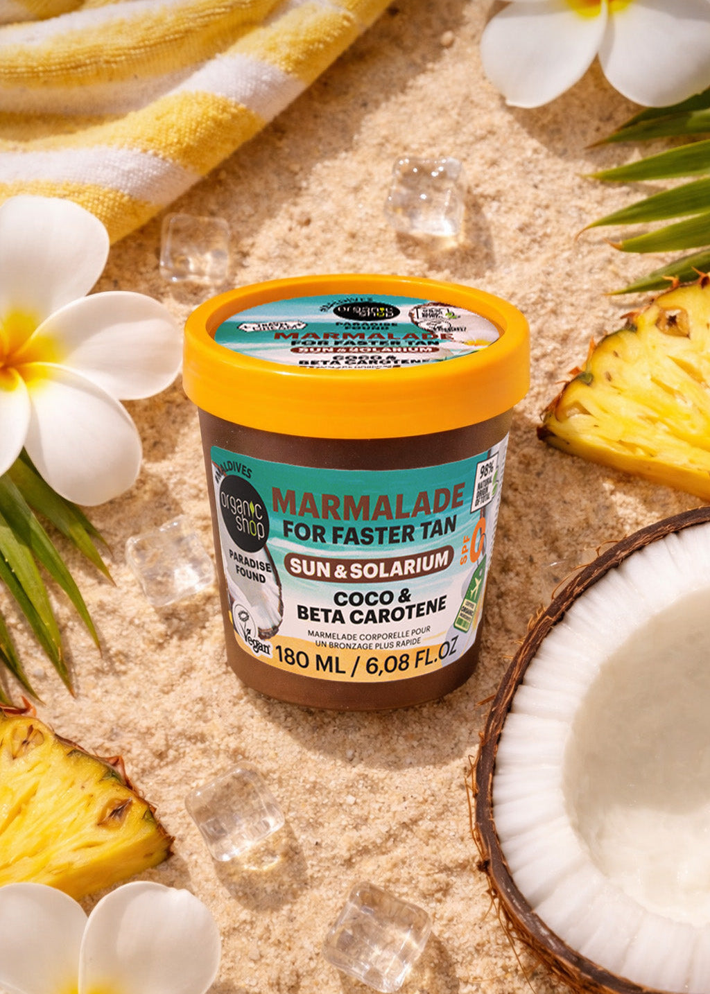 Jar of marmalade for faster tanning with tropical fruits and flowers on a sandy background